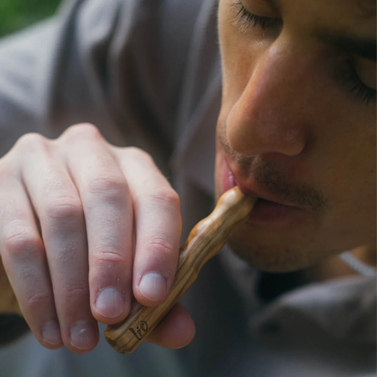 Man taking a draw from a Lio olive wood diffuser